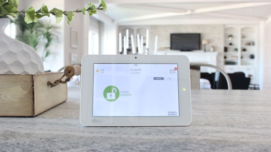 A Qolsys IQ Panel on a counter displaying a disarmed alarm. 