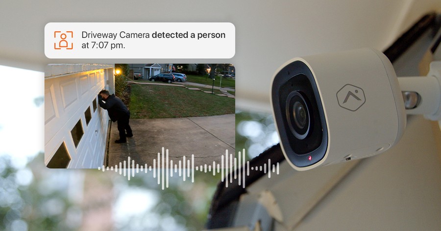 A picture of an outdoor camera with an inset of an activity detection notification at an Omaha home.