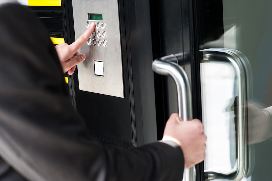 Person entering a passcode into a business access control system. 